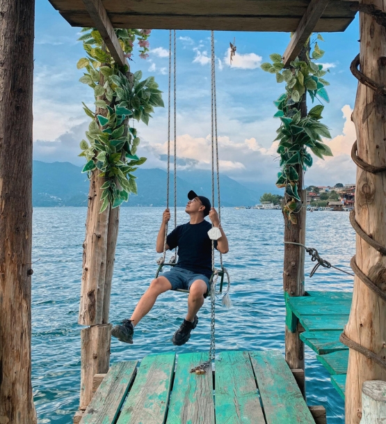 Viajero relajándose en un columpio frente al Lago de Atitlán, un destino imperdible al viajar a Guatemala.